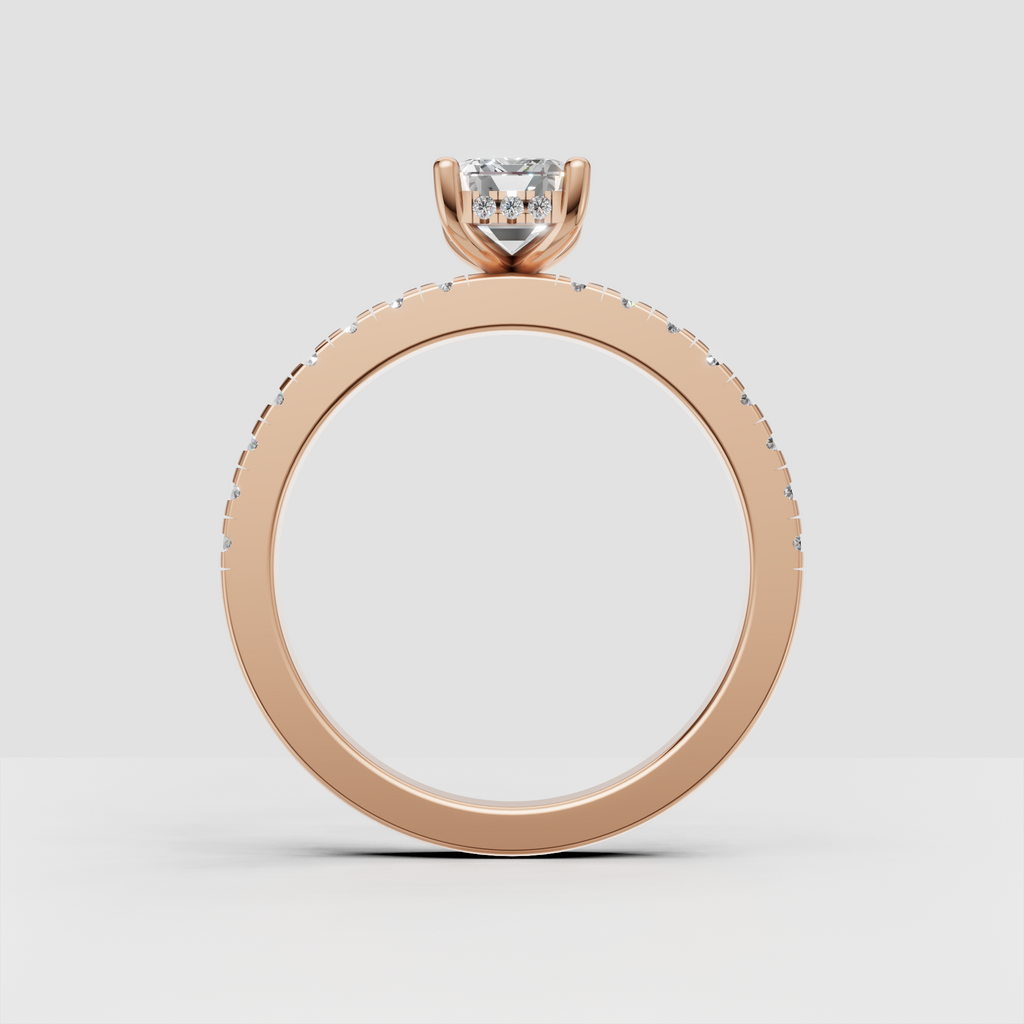 Emerald cut canter diamond with four-prong setting and paved gold shank