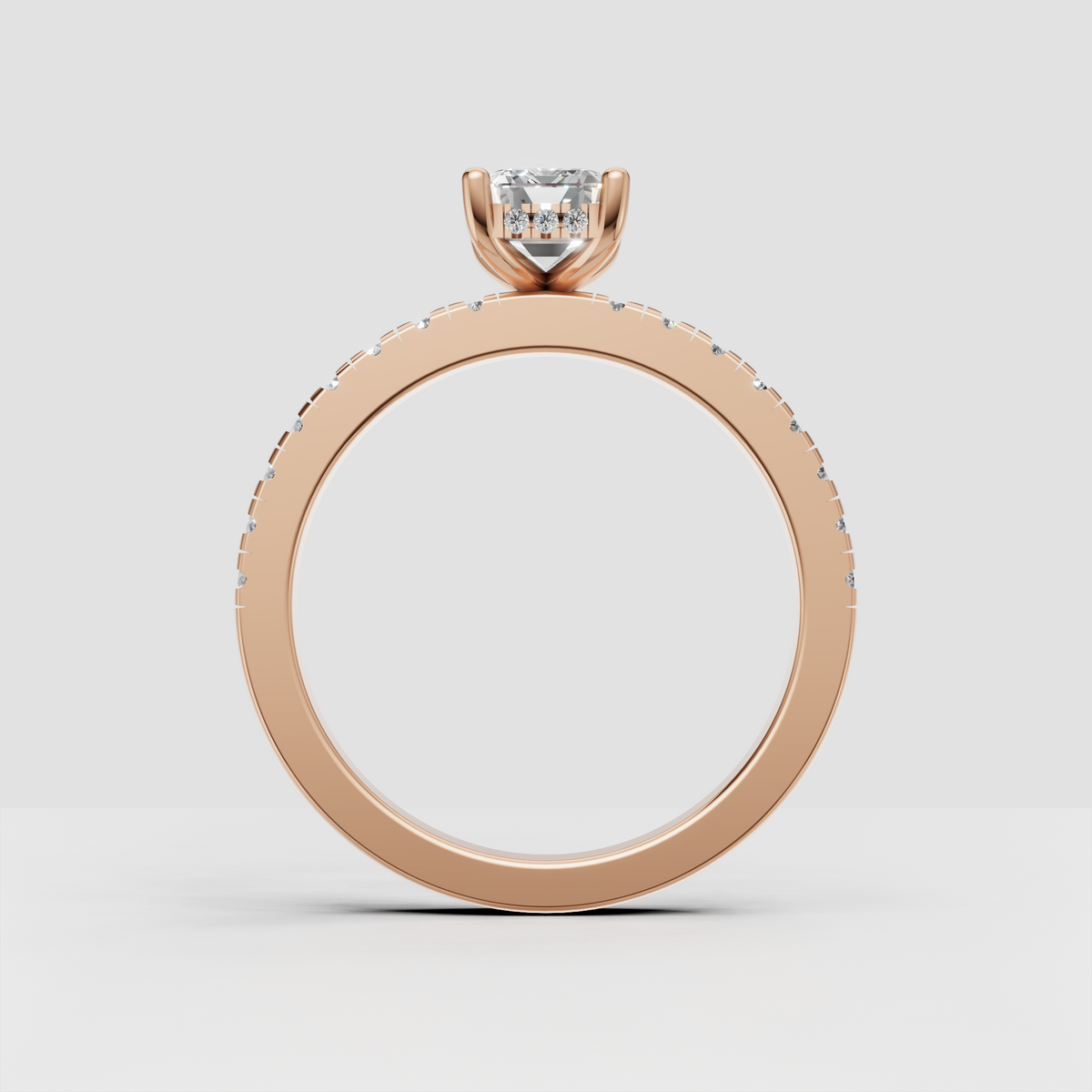 Emerald cut canter diamond with four-prong setting and paved gold shank