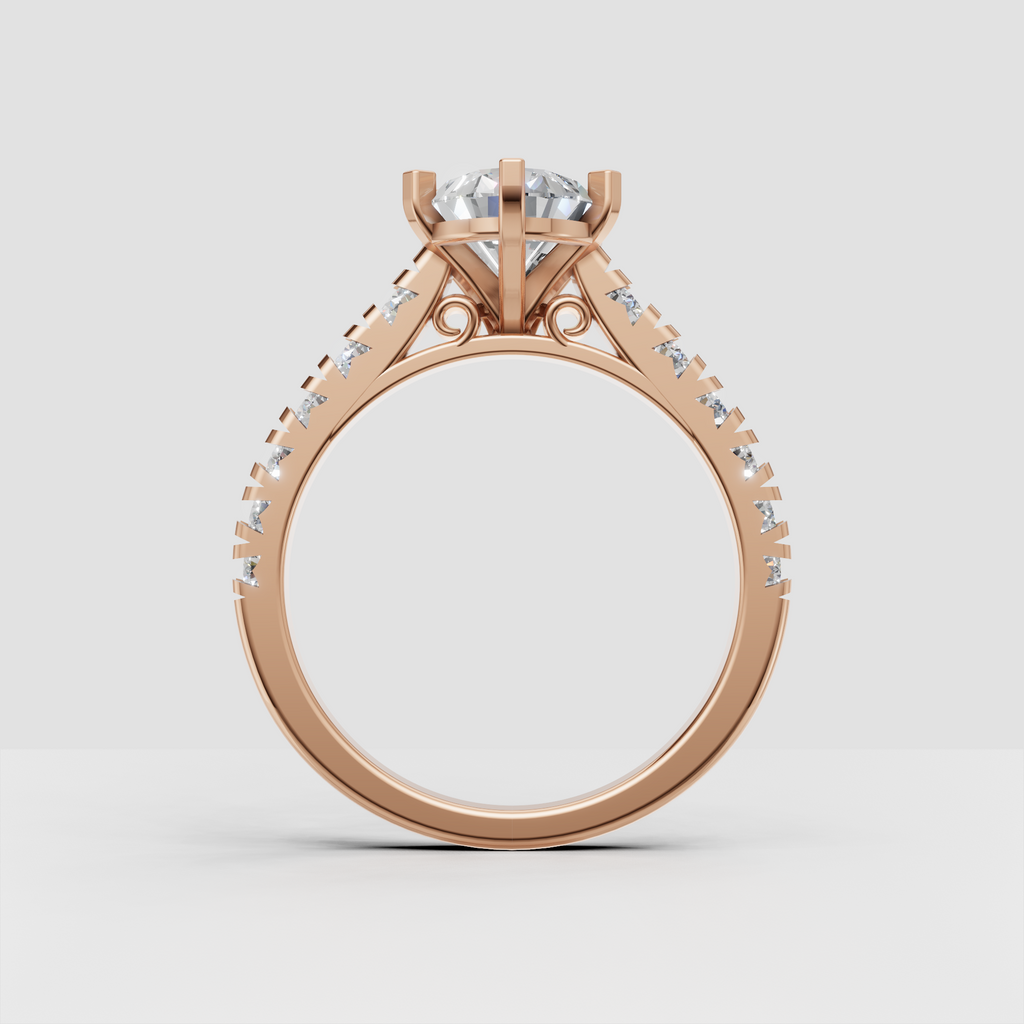 Pear shaped diamond engagement ring in yellow gold with symmetrical sparkling stones along both shoulders.