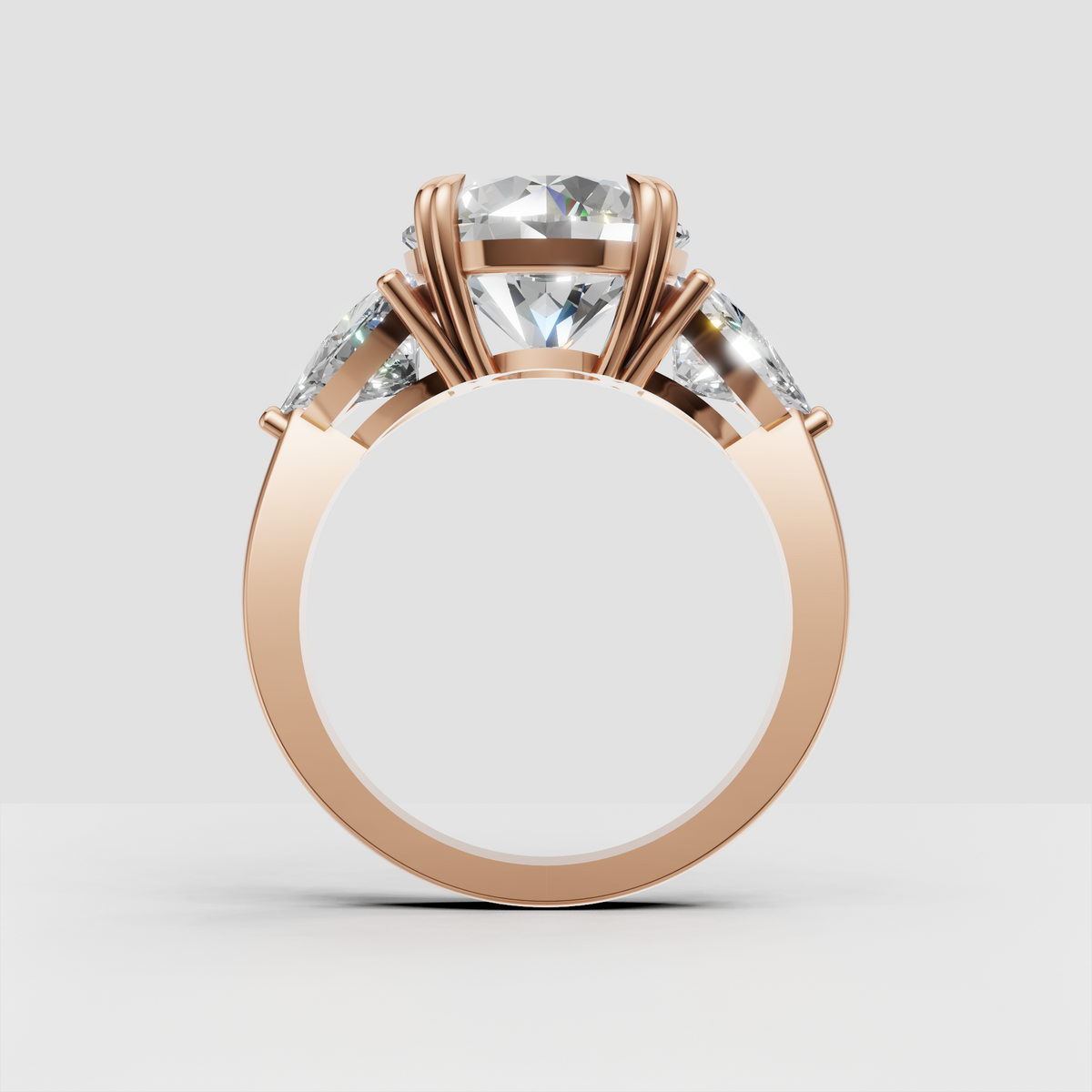 Three stone round diamond ring with polished yellow gold band and pear accents