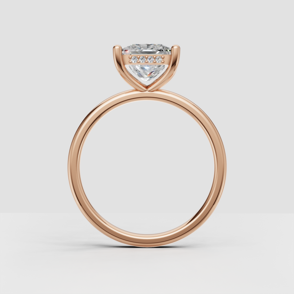 Princess cut diamond solitaire ring with four gold prongs and delicate accent stones beneath center