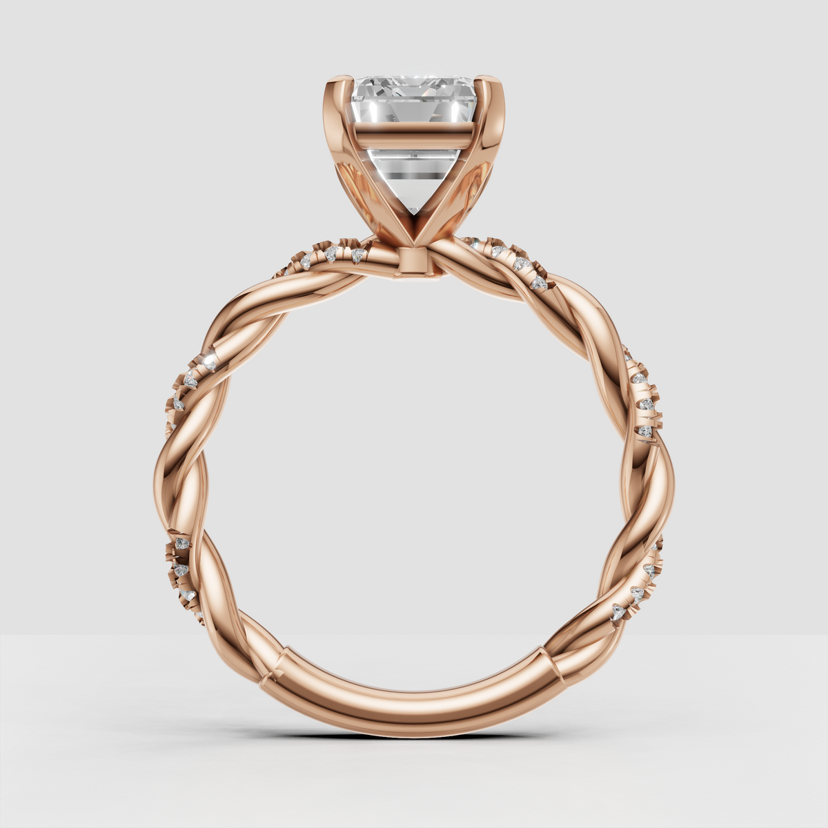 Emerald cut diamond ring with scattered pavé stones along twisted shoulders