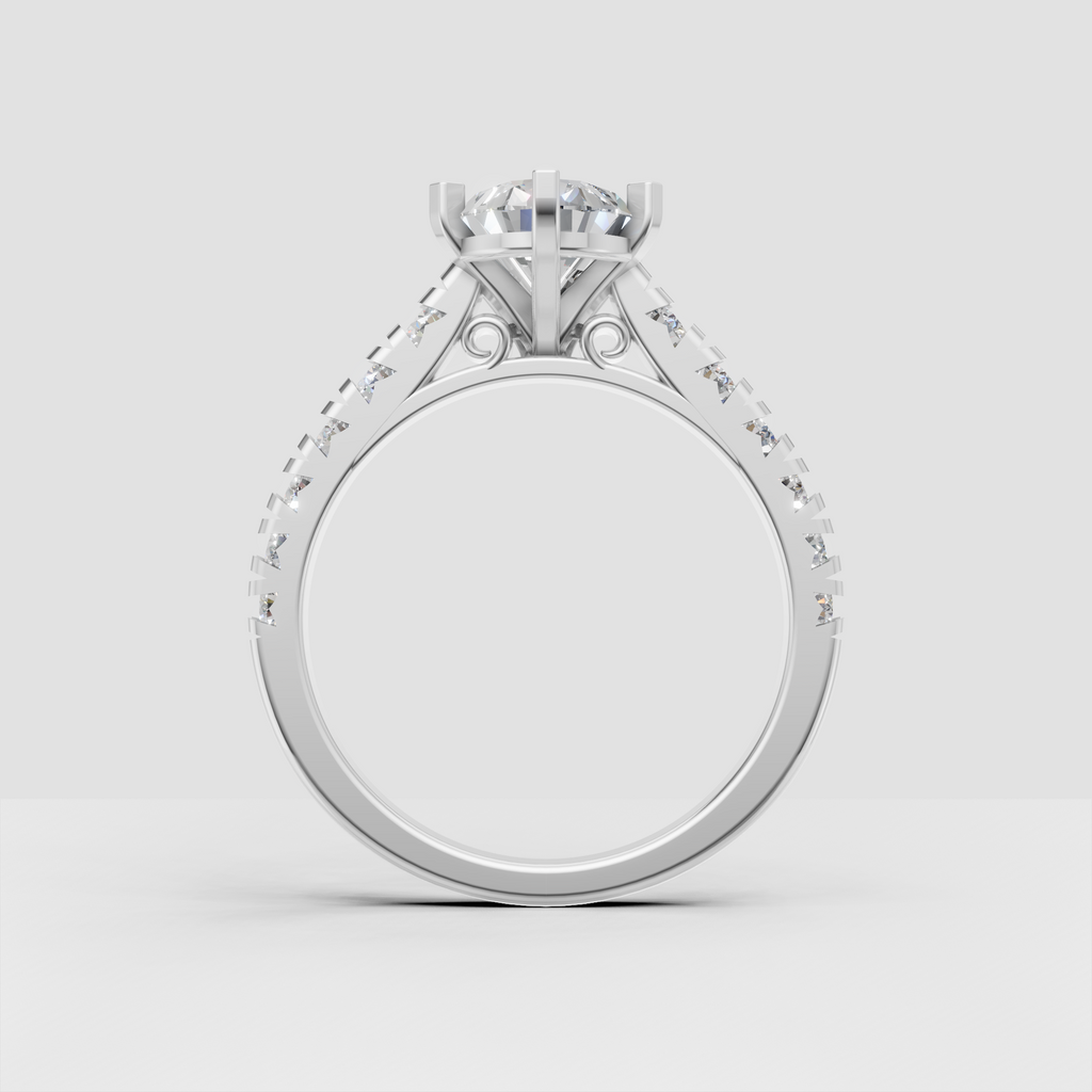 Vintage-inspired pear diamond engagement ring featuring open scroll details beneath the center setting.