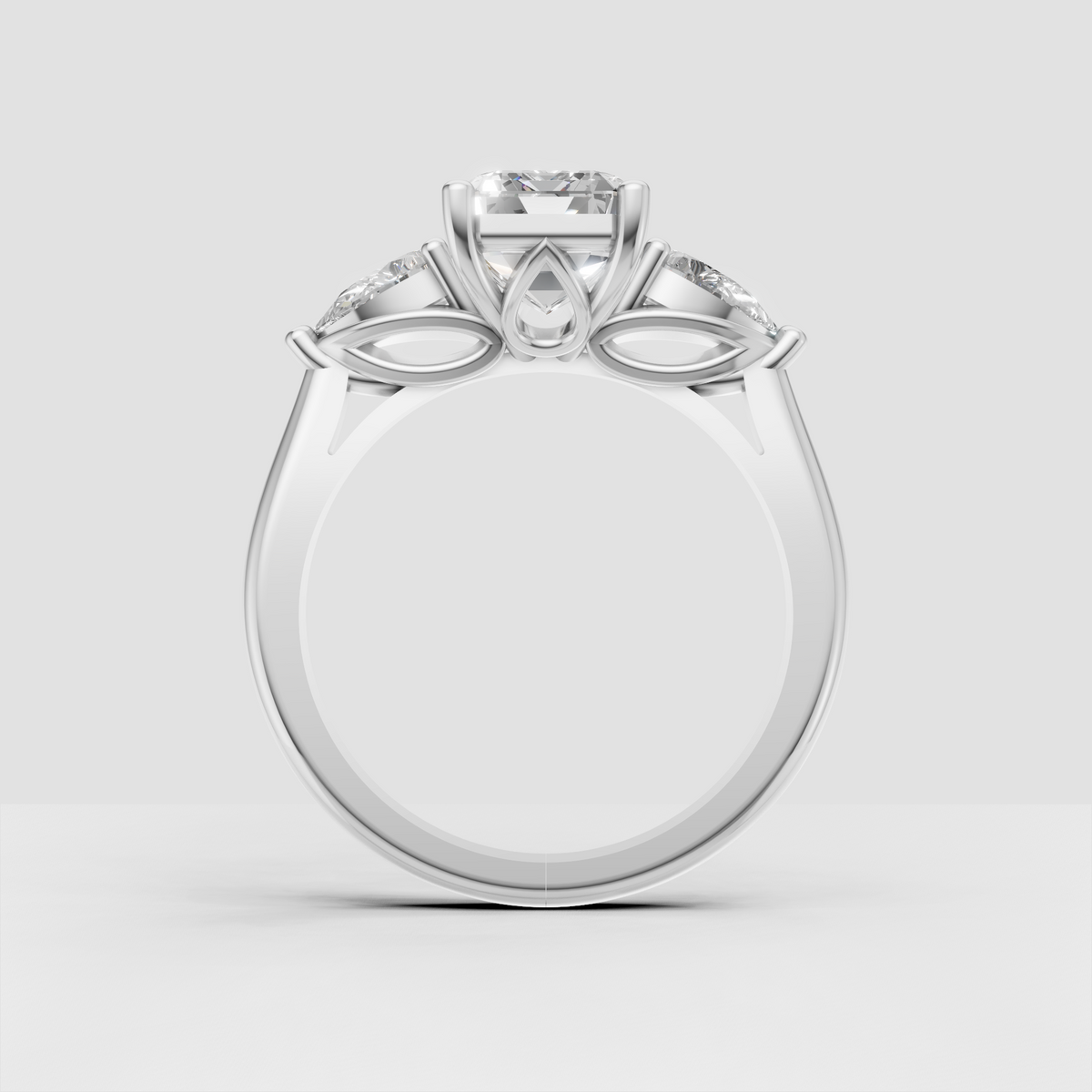 Emerald diamond ring with pear side stones