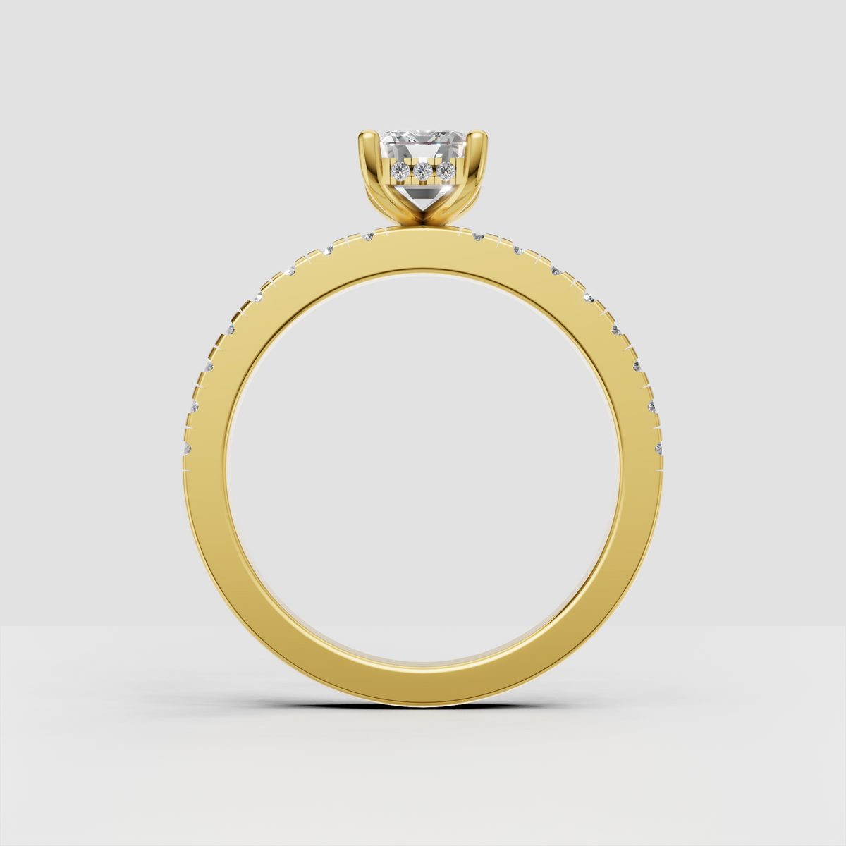 Emerald cut diamond ring featuring round pave side stones and yellow gold band