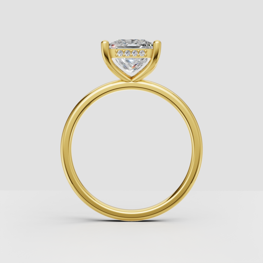 Close-up of princess cut diamond solitaire ring with polished gold band and four rounded prongs