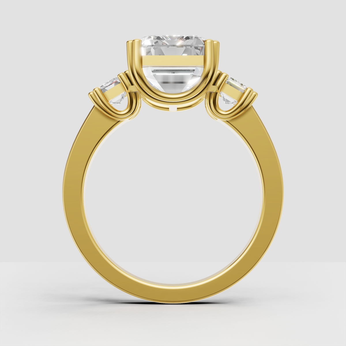 Yellow gold emerald cut three stone engagement ring