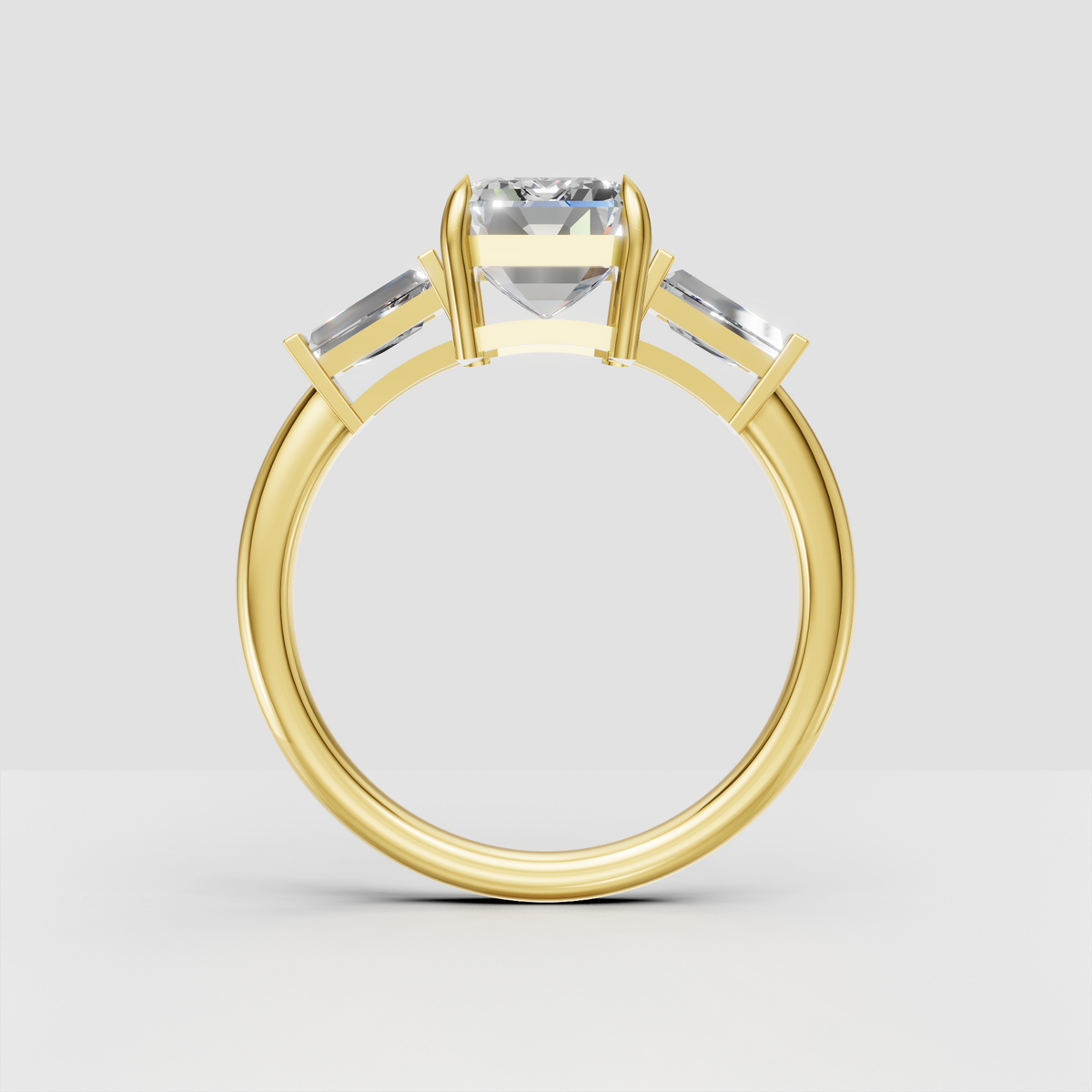 Emerald cut center diamond ring with baguette side stones and yellow gold setting