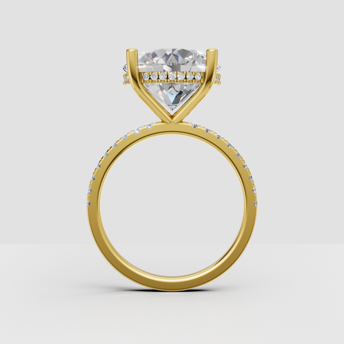 Side view of round diamond engagement ring showing hidden halo beneath the center stone and pavé shoulders.