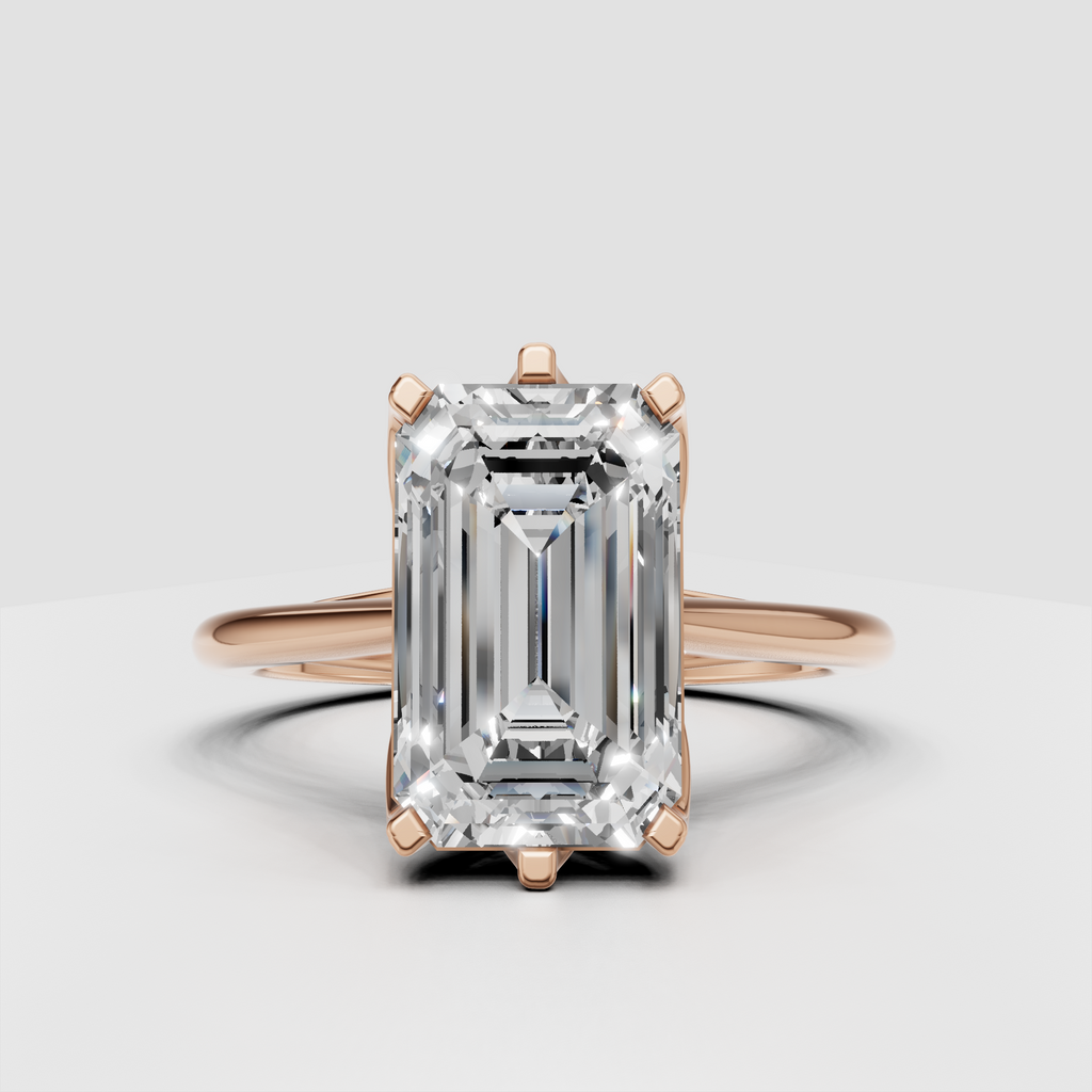 Modern emerald cut solitaire ring with sculptural shoulders