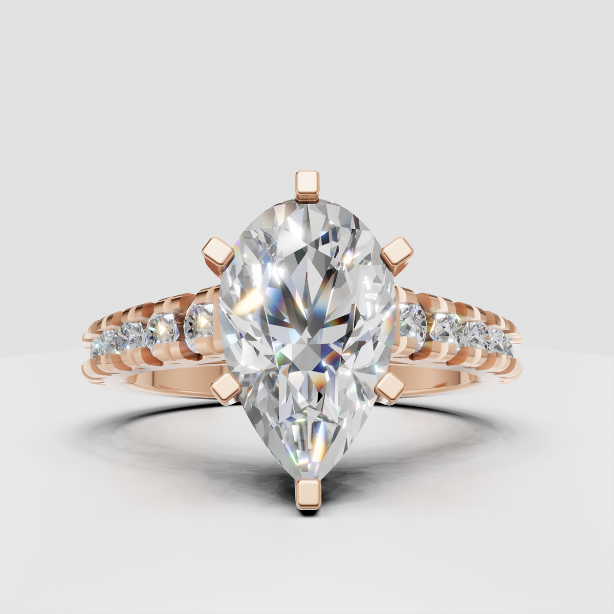 Pear shaped diamond solitaire-style ring with pavé diamond shoulders and an elevated cathedral profile.