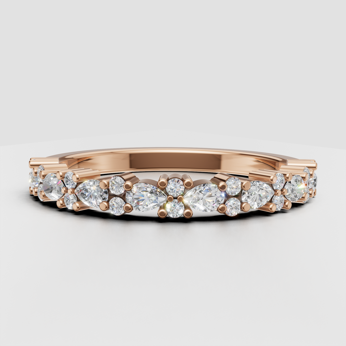Close-up of round and pear diamond half eternity band with prong details