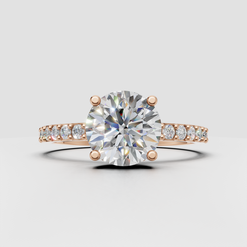 Round brilliant engagement ring with four rounded gold prongs and diamond shoulders