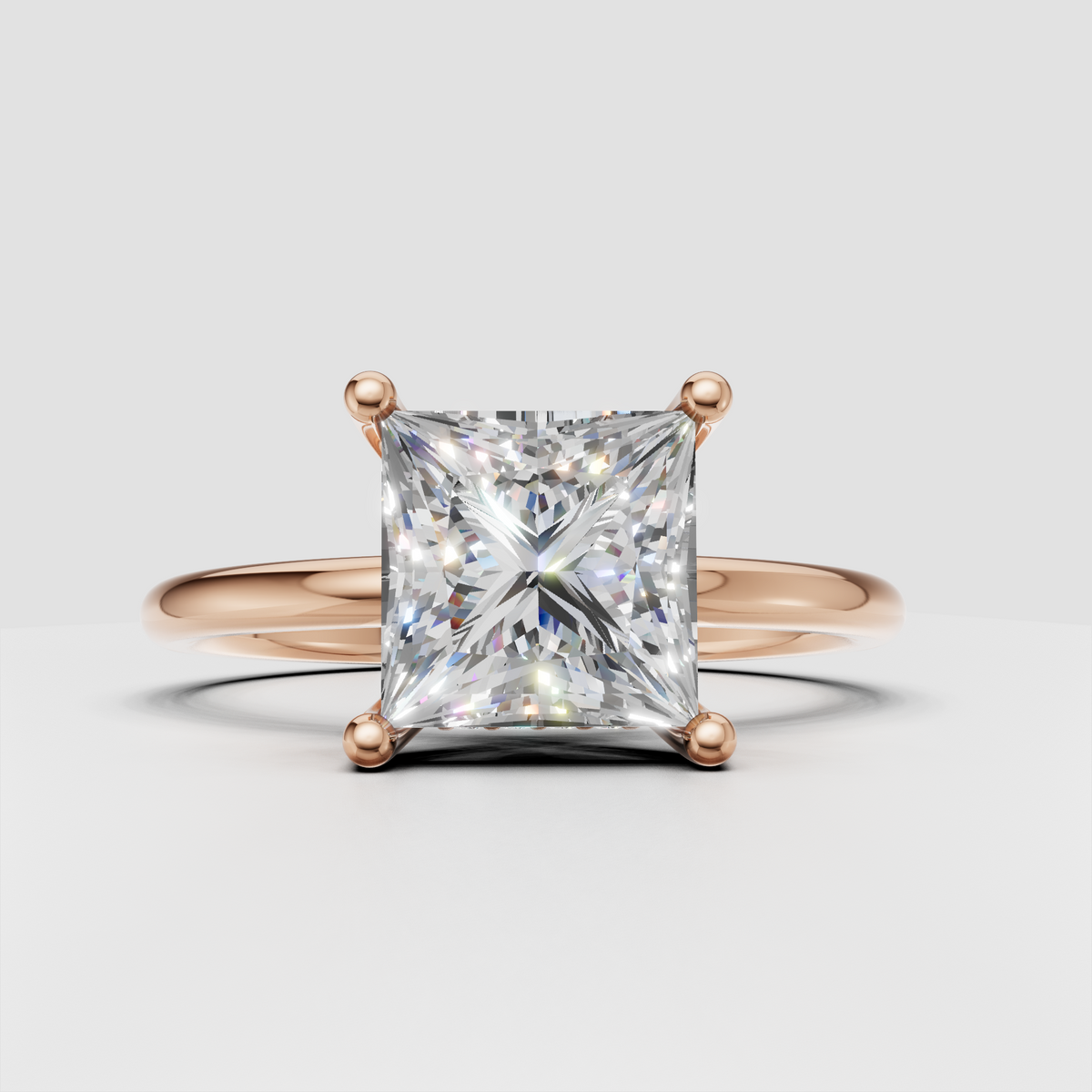 Princess cut diamond solitaire ring shown from an angled view with polished yellow gold band