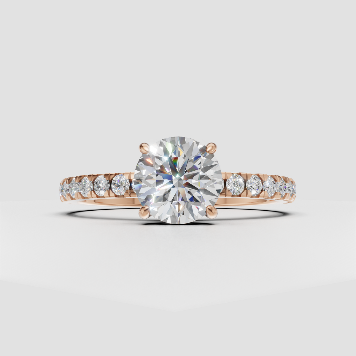 Four-prong round diamond ring with delicate gold pavé shoulders