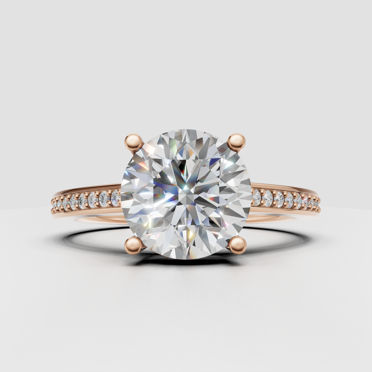 Round diamond bridal ring with slim pavé band and four-prong center setting.