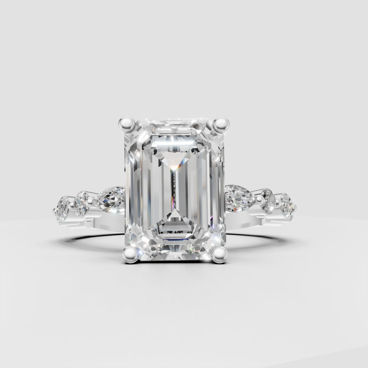 Emerald cut center stone engagement ring with four rounded prongs