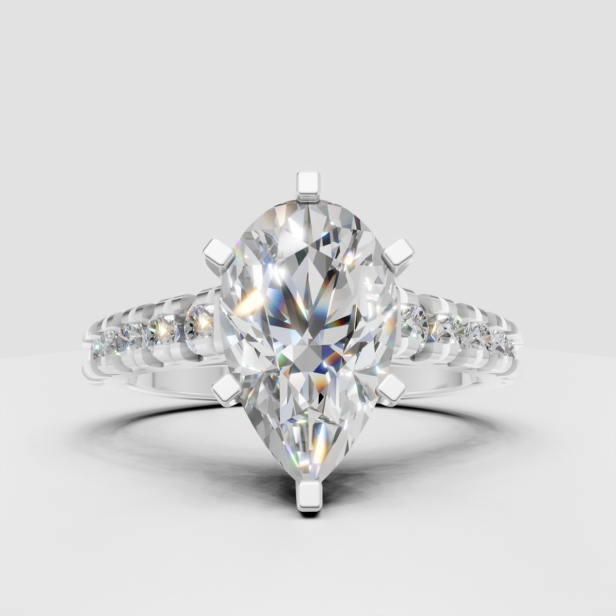 Yellow gold pear cut diamond engagement ring with brilliant side stones flowing along the upper band.