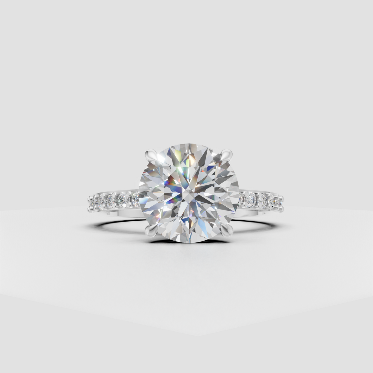 Round brilliant diamond engagement ring with delicate pavé shoulders