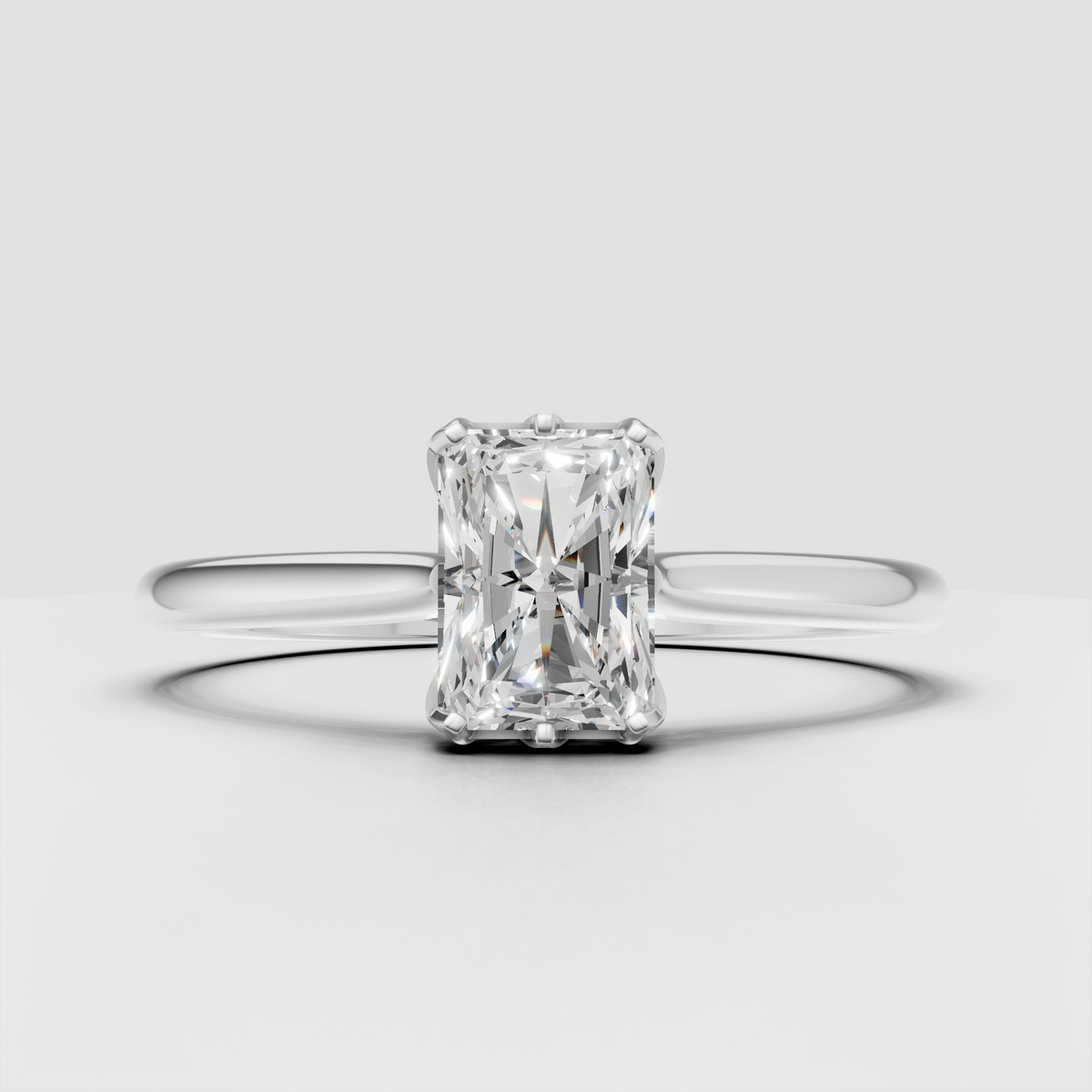 Radiant cut engagement ring featuring a sleek yellow gold solitaire band
