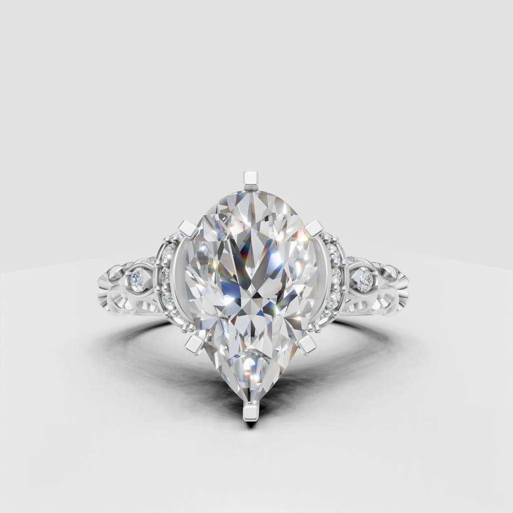 Vintage pear diamond ring with intricate scrollwork shoulders