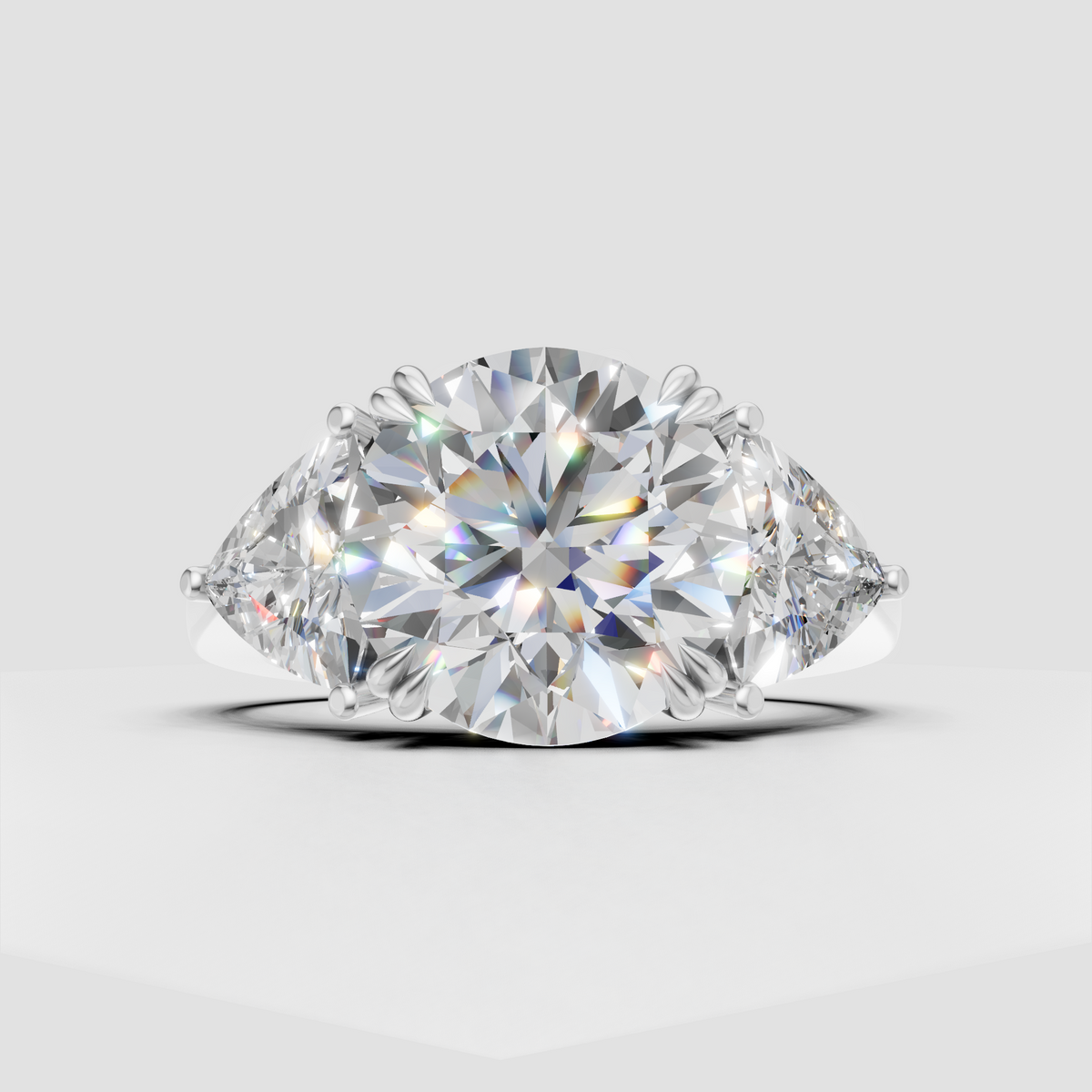 Three stone diamond engagement ring with round center and pear shaped accent stones