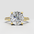 Round diamond cathedral engagement ring with pavé yellow gold band