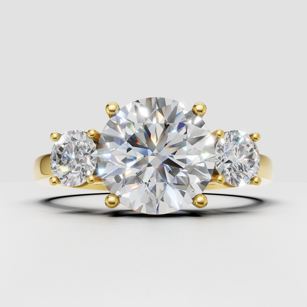 Round diamond three stone ring in polished yellow gold
