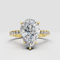 Pear-shaped Diamond four-prong pavé solitaire engagement ring in polished yellow gold