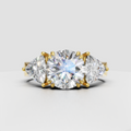 Round diamond three-stone engagement ring with Trillion side stones in gold