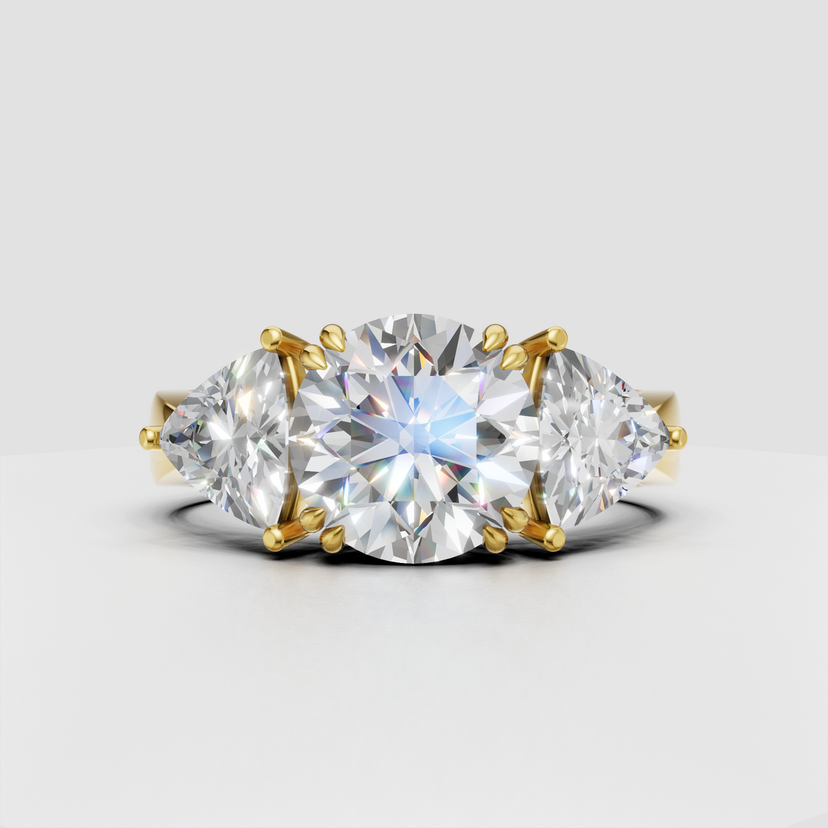 Round diamond three-stone engagement ring with Trillion side stones in gold
