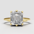 Emerald cut diamond engagement ring with polished yellow gold split shank