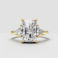 Radiant diamond three-stone engagement ring with trillion side stones in yellow gold