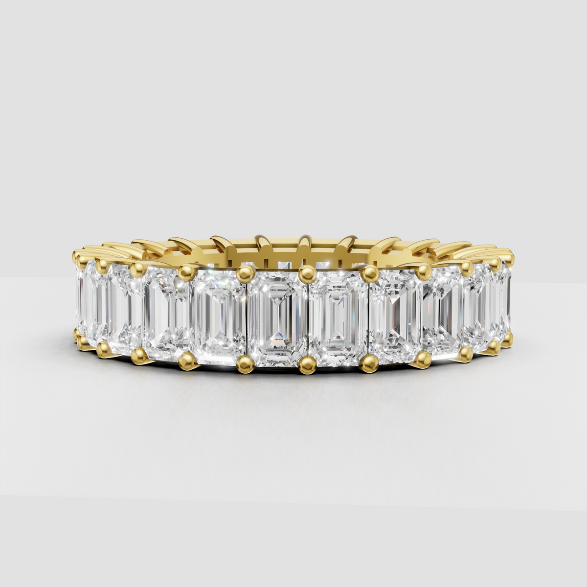 Emerald cut diamond eternity band in polished yellow gold