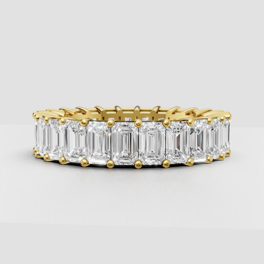 Emerald cut diamond eternity band in polished yellow gold