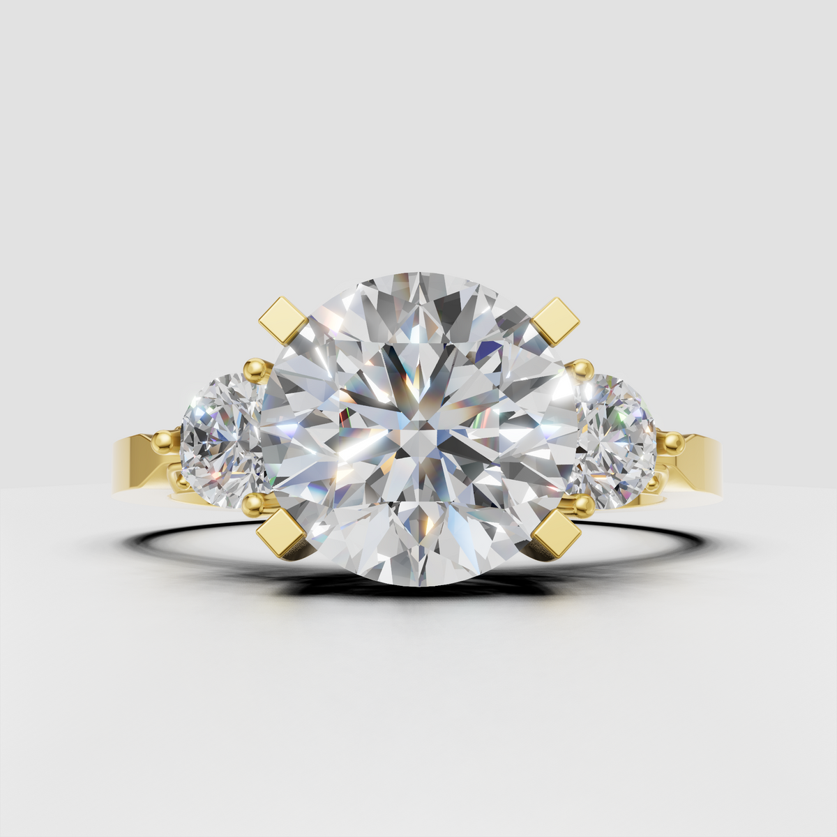 Round diamond three-stone engagement ring in polished yellow gold
