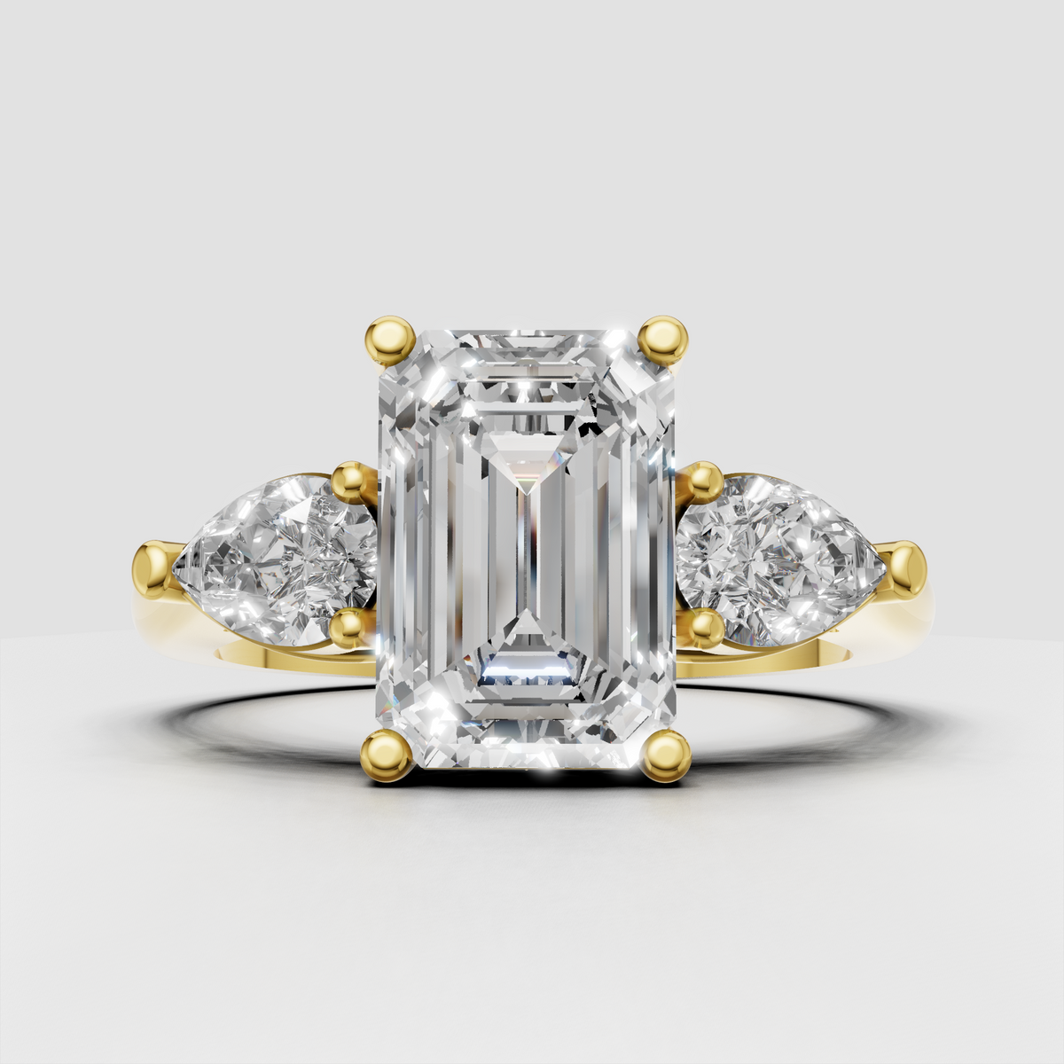 Emerald cut diamond three stone ring in yellow gold
