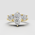 Pear shape diamond three stone yellow gold engagement ring with round side stones