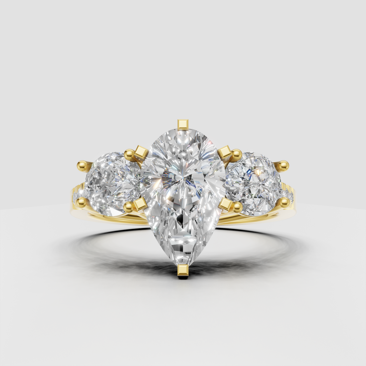 Pear shape diamond three stone yellow gold engagement ring with round side stones