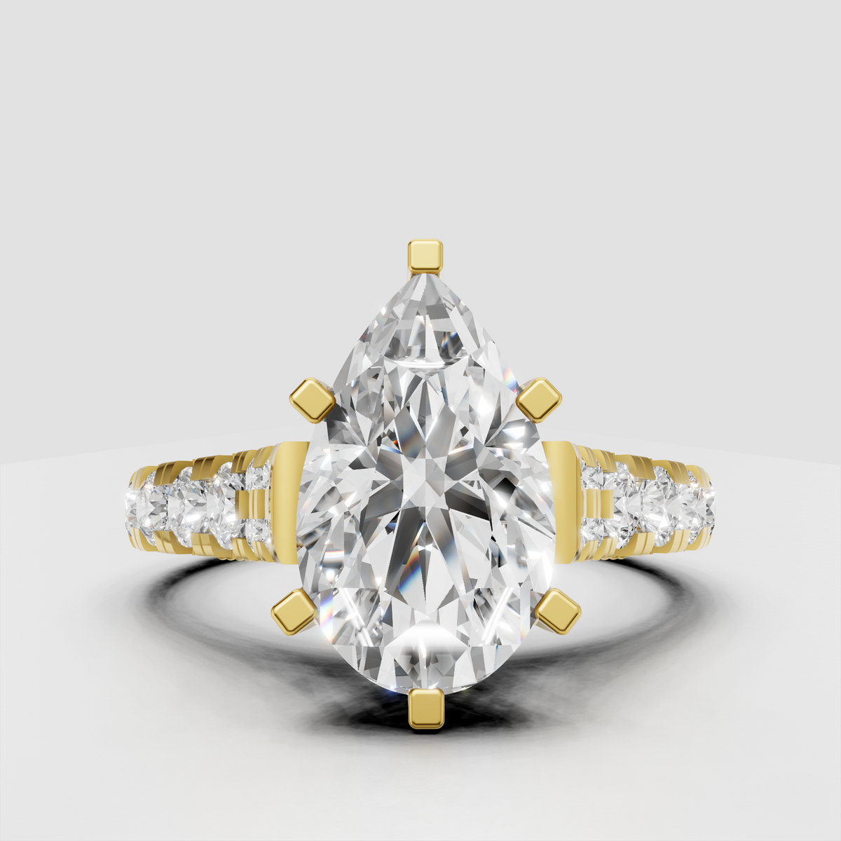 Pear diamond six-prong engagement ring with pavé side stones in yellow gold