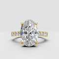 Oval diamond four-prong yellow gold engagement ring with baguette side stones