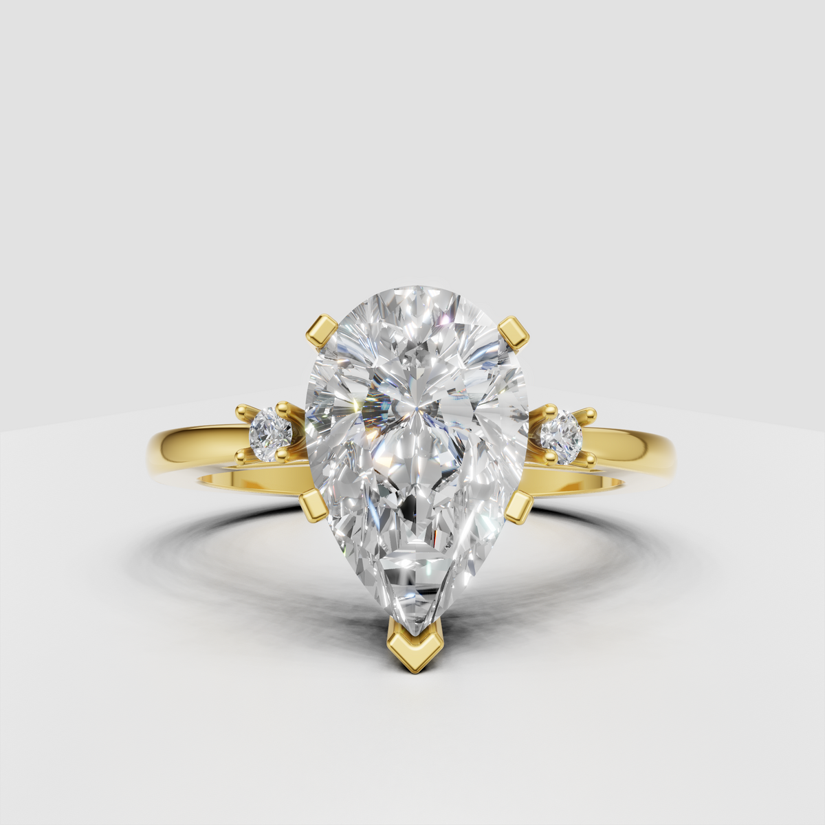 Pear cut diamond three stone engagement ring in yellow gold