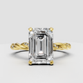 Emerald cut diamond twisted pavé engagement ring in polished yellow gold