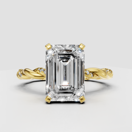 Emerald cut diamond twisted pavé engagement ring in polished yellow gold