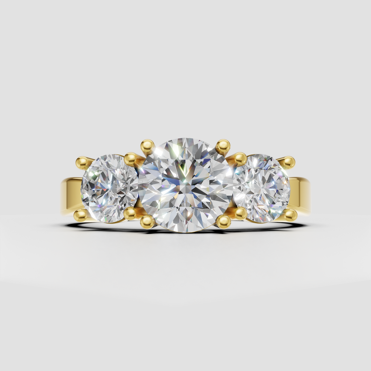 Round diamond three-stone engagement ring with pavé shoulders