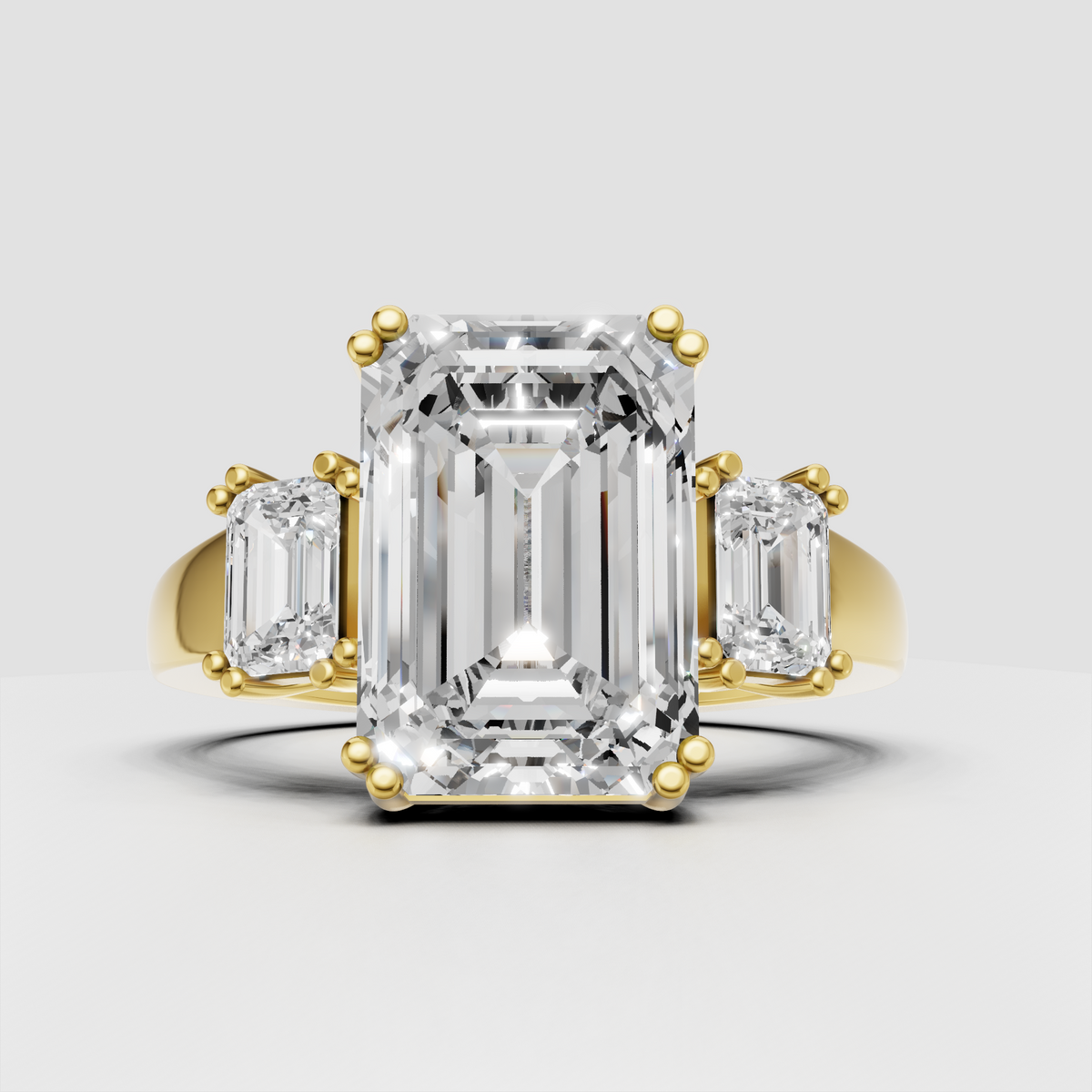 Emerald cut diamond three stone engagement ring in polished yellow gold