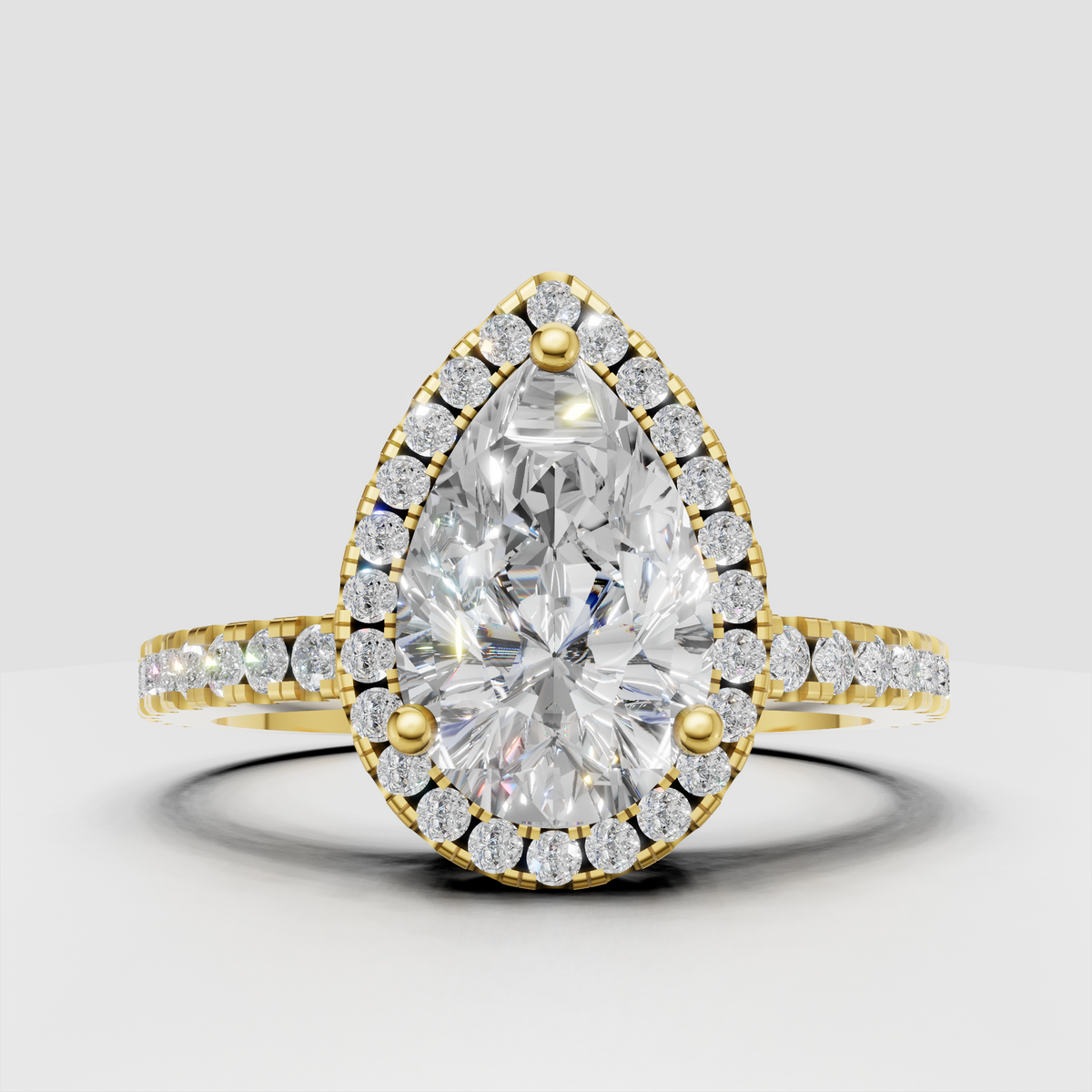Pear-shaped diamond halo engagement ring in polished yellow gold