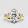 Pear cut diamond cathedral engagement ring with six-prong setting and pavé side stones in polished yellow gold.