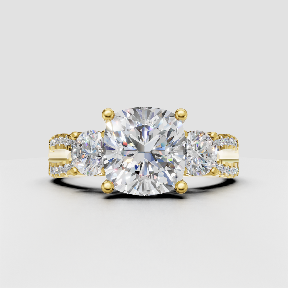 Cushion cut diamond three stone ring in yellow gold