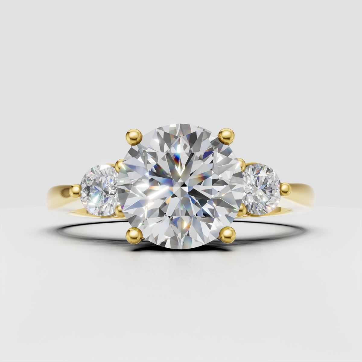 Round Diamond three-stone engagement ring with polished yellow gold band